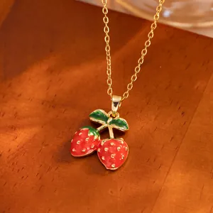 Cute minimalist gold necklace with double red strawberry pendant in a pastoral style