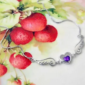 Elegant silver angel wings heart necklace with purple stone on a strawberry background