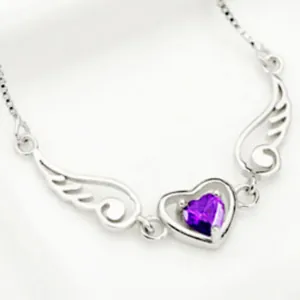Macro view of silver angel wings necklace featuring a purple heart-shaped pendant