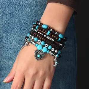 Vintage bohemian wood bead and turquoise stacked charm bracelet set worn on wrist