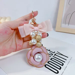 Detailed view of the elegant pink camellia keychain with lustrous pearls and bow