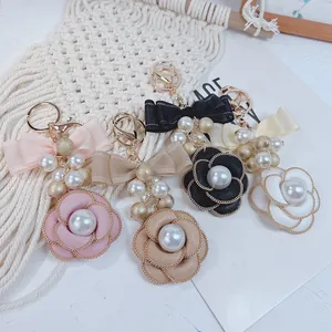 Elegant camellia flower keychain with pearls and double-layer bow bag charm
