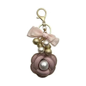 Elegant camellia flower keychain with pearls and pink ribbon bow bag charm for women