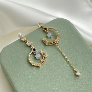 Asymmetrical moon and star earrings with long tassels and zircon stones detail