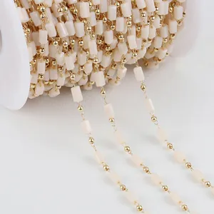 Detailed close-up of 14K gold-filled jewelry chain with creamy crystal square beads.