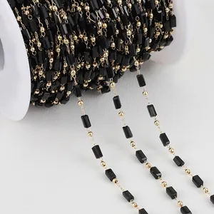Close-up detail of black rectangular crystal beads and gold copper bead chain for DIY jewelry
