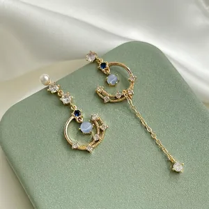 Elegant asymmetric star moon tassel earrings with blue zircon and cat eye stone.
