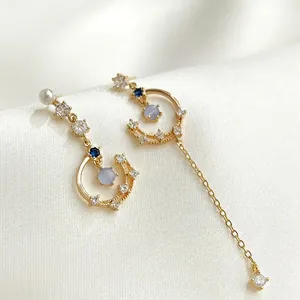 Elegant asymmetric gold star and moon tassel earrings featuring zircon and pearl accents.