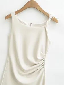 Close-up of elegant cream white sleeveless dress featuring ruched waist and shoulder detail