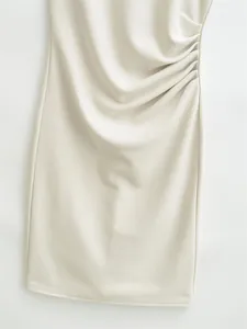 Close-up showing the elegant ruched side detail on a cream sleeveless bodycon dress.