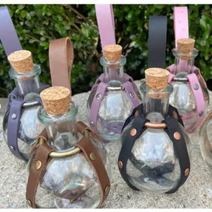 Selection of round glass apothecary bottles in colorful leather holders for display