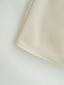 Detailed close-up of beige midi dress hem with precise double-needle stitching.