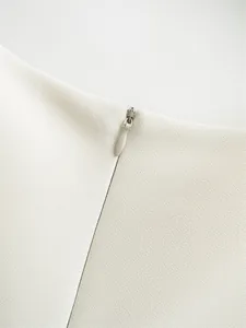 Close-up detail showing the high-quality invisible zipper on this white elegant sleeveless dress