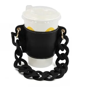 Close-up of stylish black leather coffee cup sleeve with chunky matte chain handle