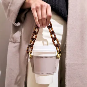 Elegant leather coffee cup sleeve featuring a stylish detachable tortoise shell chain handle
