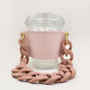 Chic pink leather coffee cup sleeve with a chunky decorative plastic chain strap.