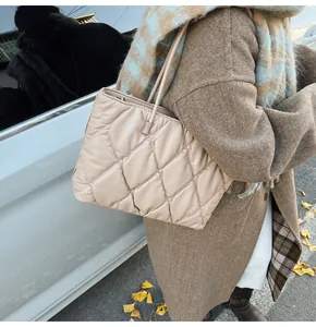 Stylish beige quilted puffer tote bag for women in a winter street setting
