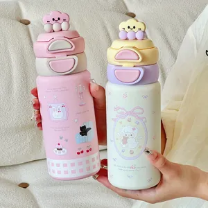 Detail shot of pink and cream cartoon stainless steel vacuum flasks with cute lids
