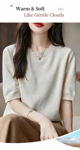 Primo piano di un maglione in maglia di cotone crema con consistenza morbida e scollo a giro
