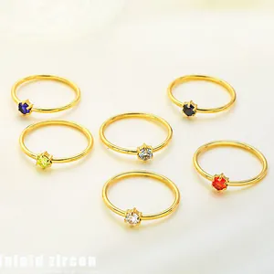 Detailed view of six-prong gold rings set with various colorful round zircon stones