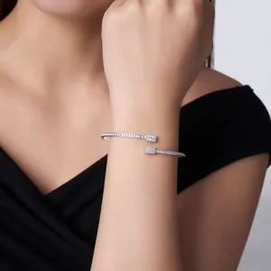 Close-up of a delicate silver open bangle with moissanite stones on a model's wrist