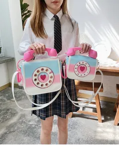 Quirky telephone-shaped crossbody bag featuring a vibrant pink and blue gradient finish