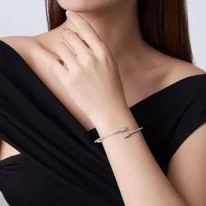 Detailed shot of a sterling silver moissanite open bangle worn on a model's wrist