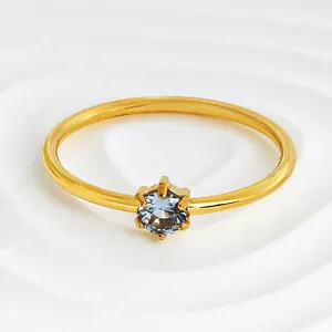 Macro view of gold-plated stainless steel ring with six-prong set blue zircon