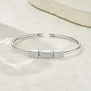 Macro view of sterling silver open cuff bracelet with three shimmering pavé rectangular charms