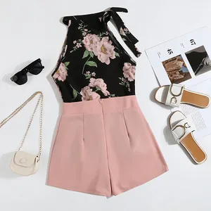 Stylish two-piece summer set with floral halter top and pink shorts flat lay