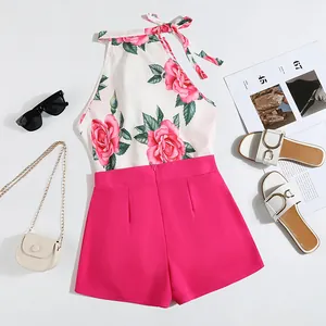 Stylish floral halter top and bright pink shorts set laid out with summer accessories