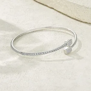 Detailed macro view of silver open bangle set with sparkling moissanite stones