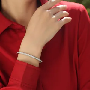 Close-up detail of an elegant sterling silver moissanite open bangle worn on a wrist