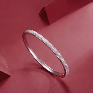 Detailed view of an elegant silver moissanite bangle featuring pavé set stones
