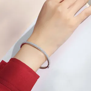 Close-up shot of a sparkling sterling silver moissanite bangle worn on a woman's wrist