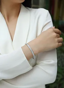 Elegant silver Moissanite bangle for women shown on a model wearing a white blazer