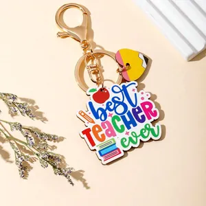 Detailed macro view of 'best TEACHER ever' colorful acrylic keychain with gold clasp.