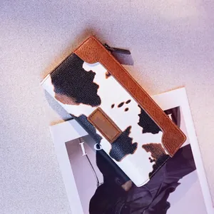 Close-up of a stylish cow print PU leather long wallet for women with zipper