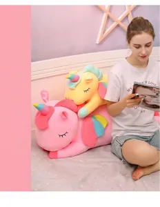 Close-up detail of soft pink and yellow unicorn plush toys in a cozy bedroom scene