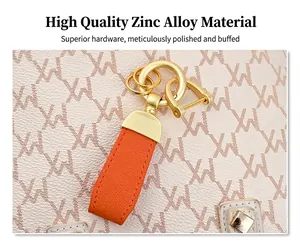 Close-up of orange leather keychain with matte gold zinc alloy hardware detail for bags
