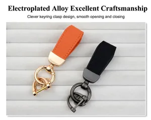 Detail view of two goat-grain leather keychains in orange and black with alloy rings.