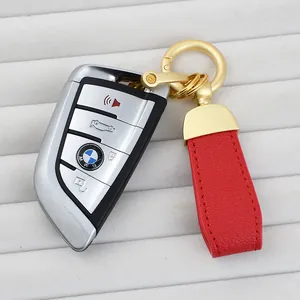 Premium red goat grain leather car keychain with elegant gold hardware on white background