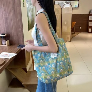 Gros plan détaillé d'un sac cabas en toile avec imprimé plume de paon bleu au café