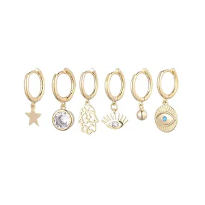 Set of 6 gold hoop earrings with star, hamsa hand, and evil eye charms for women.