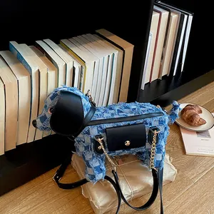 Detail shot of a cute dog-shaped blue denim crossbody bag with black leather accents