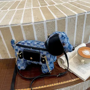 Detailed view of the cute blue denim dog-shaped crossbody bag on a wooden table.
