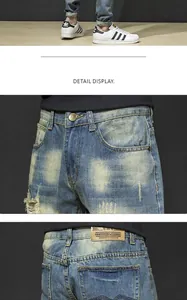 Gros plan sur un jean en denim bleu délavé pour homme avec des détails de genoux déchirés