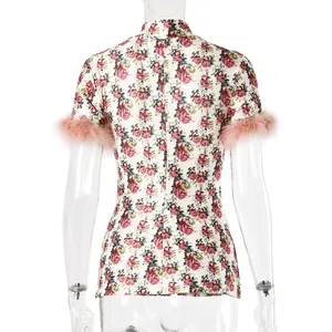 Detailed back view of floral high-neck top featuring pink feather trim on short sleeves