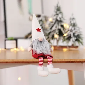 Handmade faceless Christmas gnome plush doll sitting on a wooden table with lights
