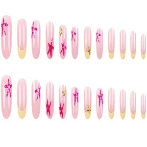 Detailed view of French press-on nails featuring cute pink and gold starfish patterns